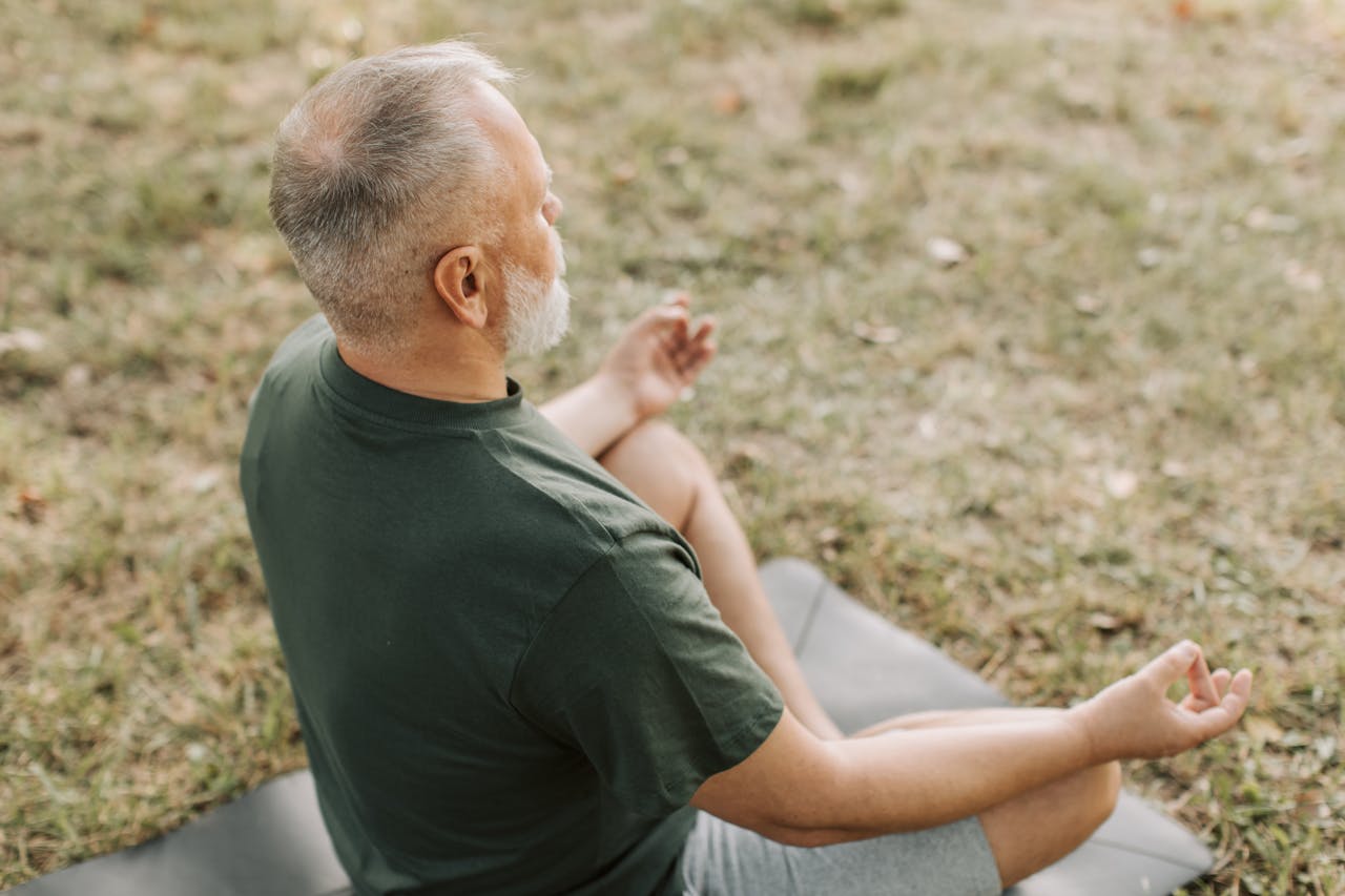 An Elderly Man Meditating in Lotus Position